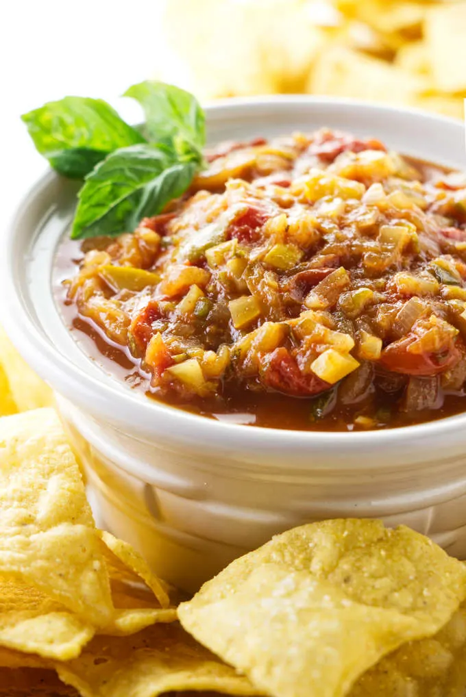 Zucchini salsa in a dish next to tortilla chips.