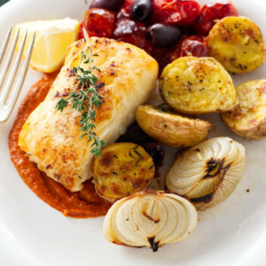 A serving of baked sea bass on romesco sauce and vegetables