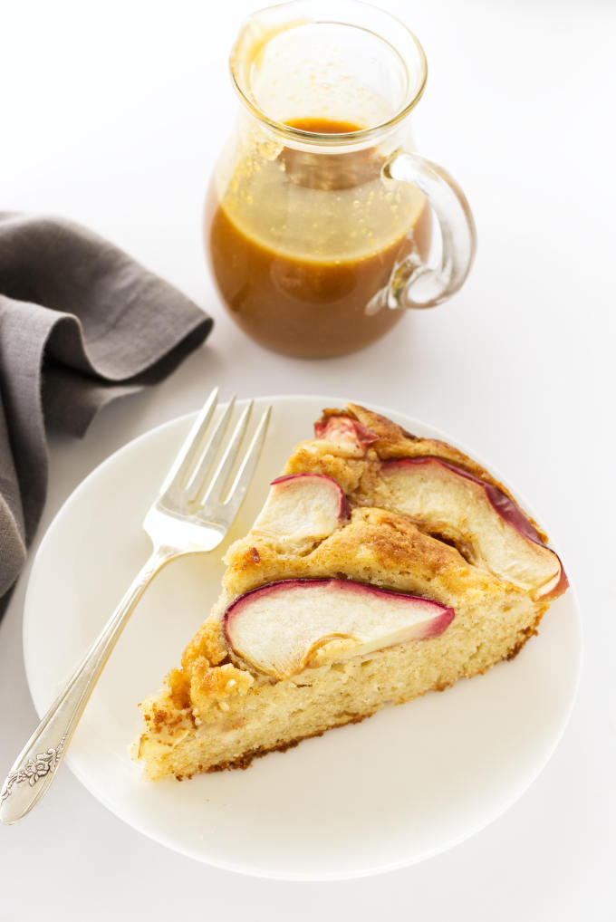 A serving of Apple Skillet Cake with a jug of caramel sauce