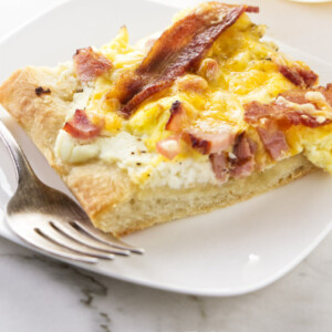 A slice of breakfast pizza on a serving plate.