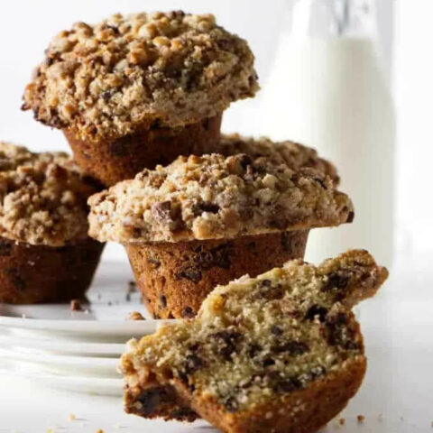 Chocolate chip muffins stacked in front of milk.