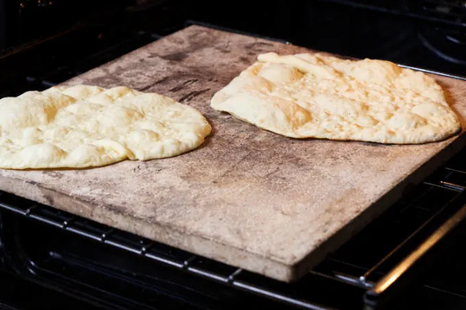 Cooking naan bread in a oven on a pizza stone.