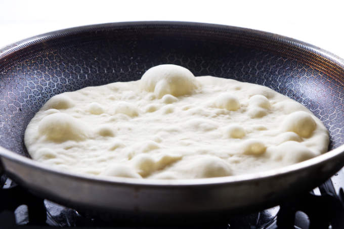 Cooking naan bread in a skillet.