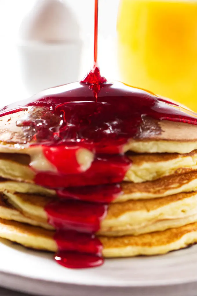 Pouring syrup over pancakes.