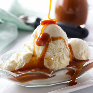 Drizzling caramel sauce over vanilla ice cream.