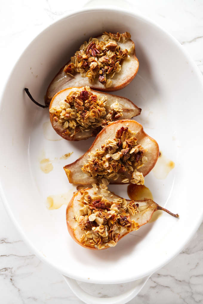 Granola on top of pears in a baking dish.