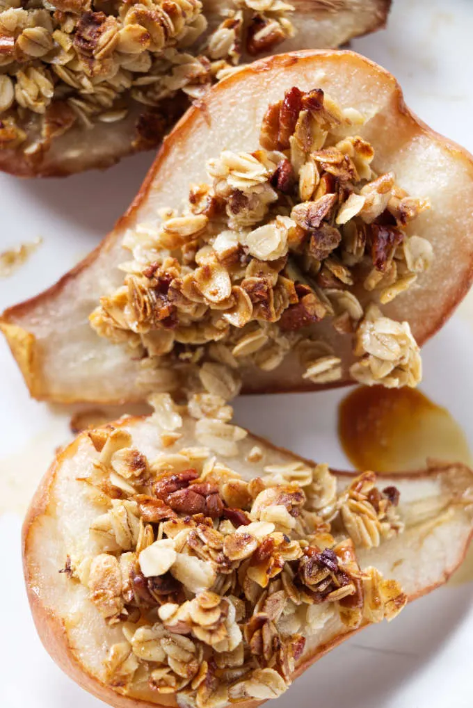 A close up of two pear halves topped with granola.