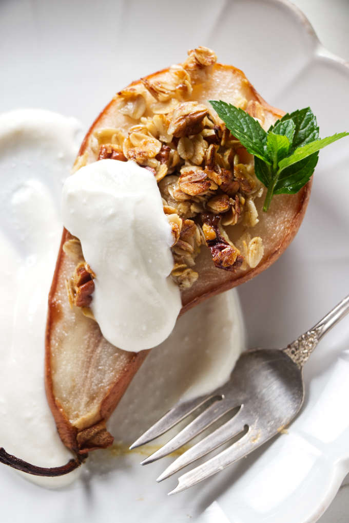 A baked pear topped with granola and ricotta.