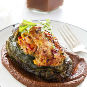 poblano pepper, mole sauce on a plate. Mole sauce in background
