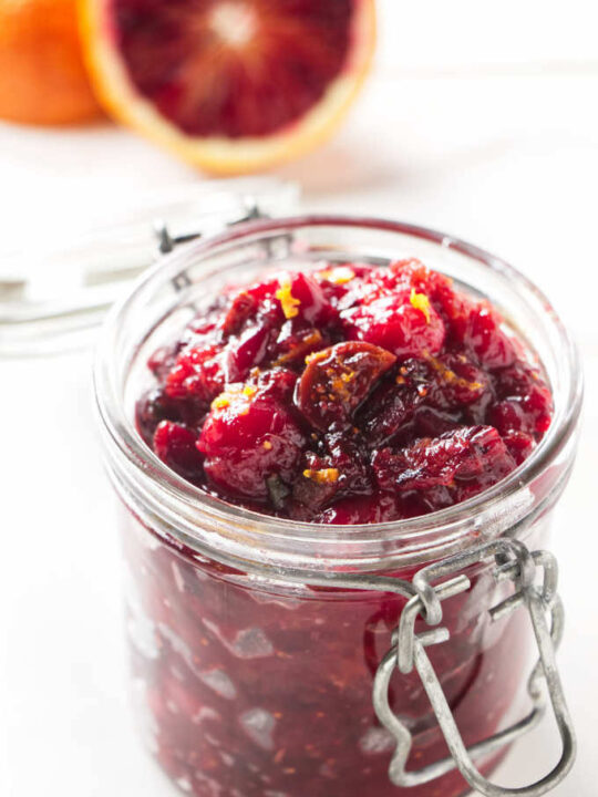 A jar filled with cranberry chutney.