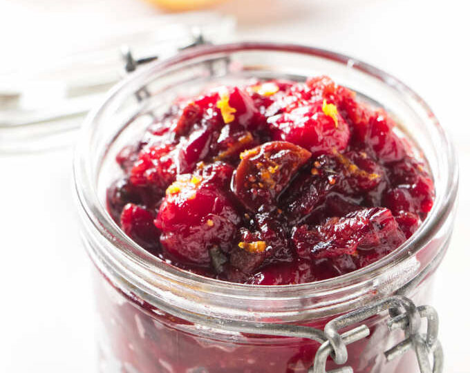 A jar filled with cranberry chutney.