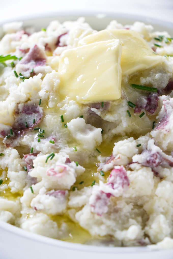 Butter melting over a bowl of mashed red potatoes.