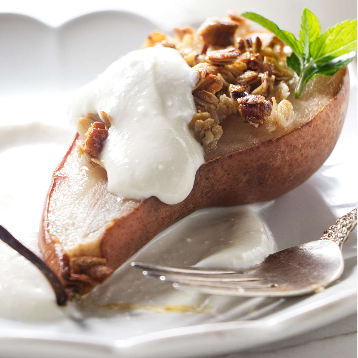 A pear half topped with granola and ricotta cream.