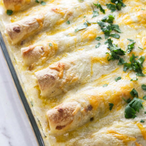 A casserole dish with white chicken enchiladas.