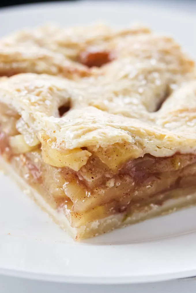 Close up view of a square serving of apple pie.