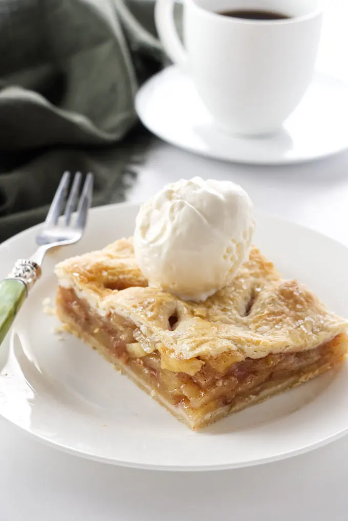 A serving of apple slab pie on a plate with a fork