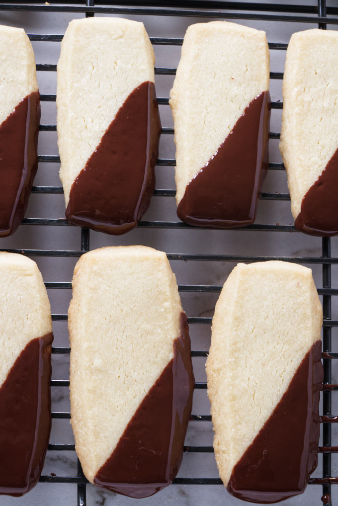 Chocolate dipped shortbread cookies cooling on a rack.