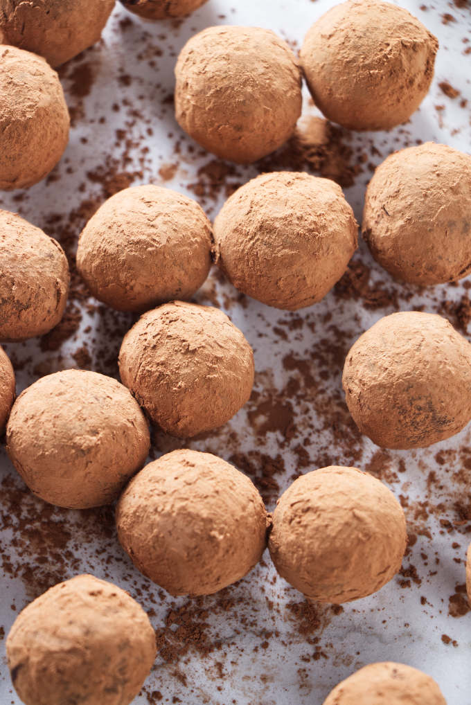 Several dark chocolate truffles coated in cocoa powder.
