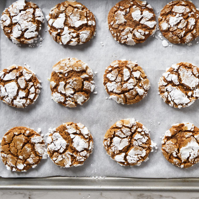 Gingerbread crinkle cookies on a sheet pan.