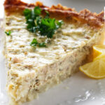 A slice of a salmon quiche with a crisp potato crust.