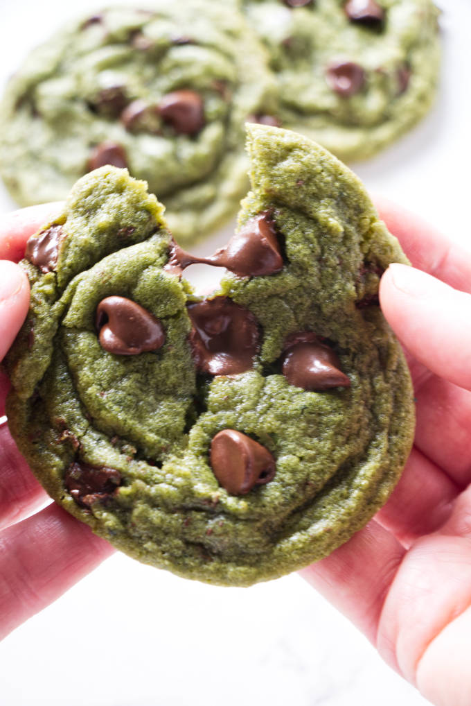 A matcha chocolate chip cookie with warm, melted chocolate chips.