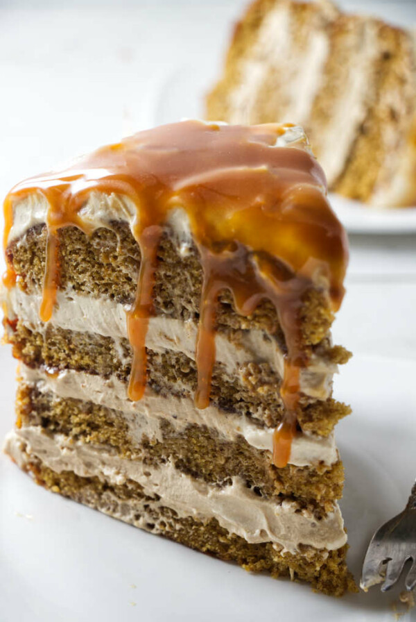 A pumpkin layer cake with caramel dripping off the top.