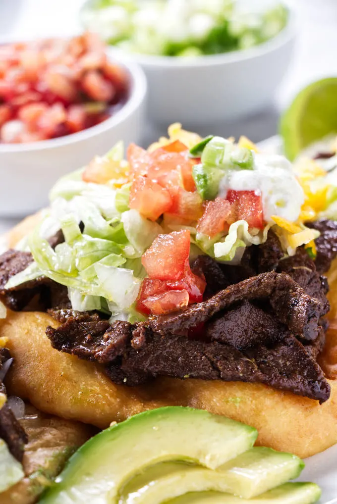 Steak strips and taco fixings on Indian fry bread.