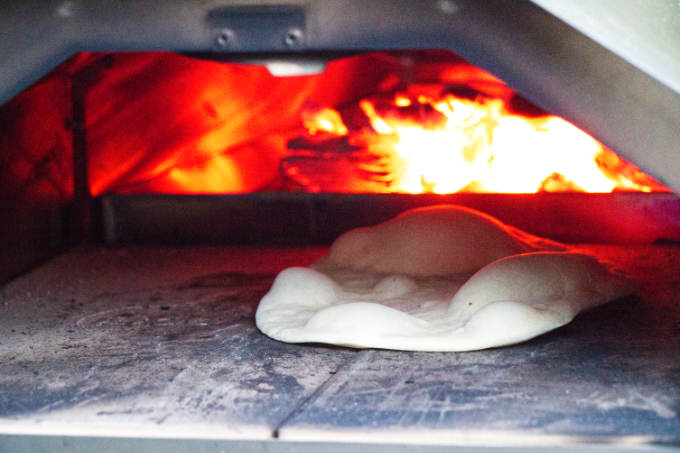 Cooking naan bread in a Ooni pizza oven.