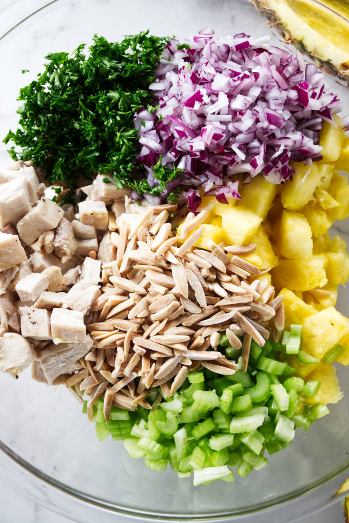 A bowl filled with ingredients for a pineapple chicken salad.