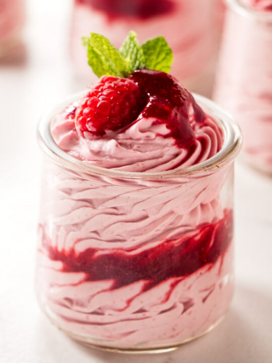A dessert cup filled with raspberry mousse.