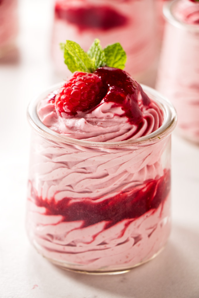 A dessert cup filled with raspberry mousse.