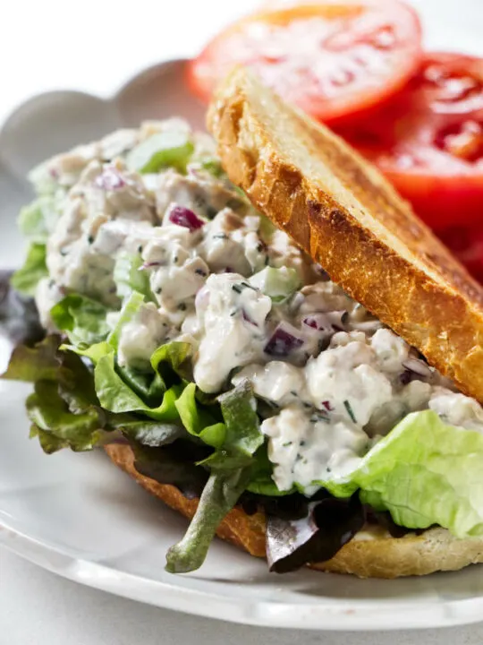 A chicken salad sandwich on a bed of lettuce.