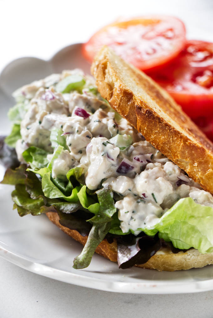 A chicken salad sandwich on a bed of lettuce.