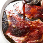 Pouring sake soy marinade over beef steaks.