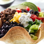 A beef taco salad in a tortilla bowl.