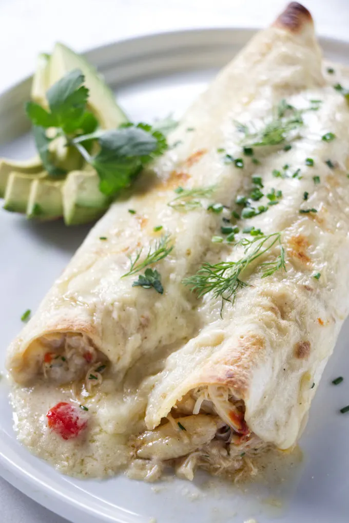 Two crab enchiladas on a plate.