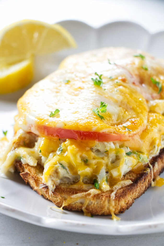 A crab melt sandwich with melted cheese.