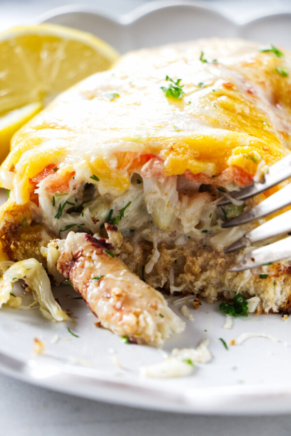 A fork scooping up the filling in a crab melt.