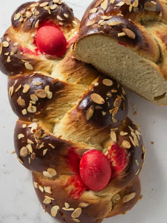 Two loaves of Greek Easter bread with red eggs.