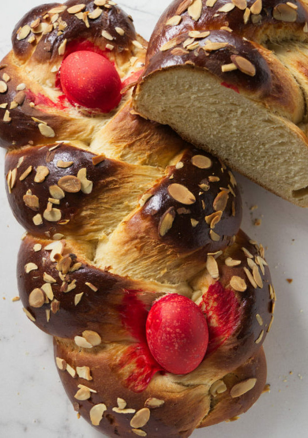 Two loaves of Greek Easter bread with red eggs.