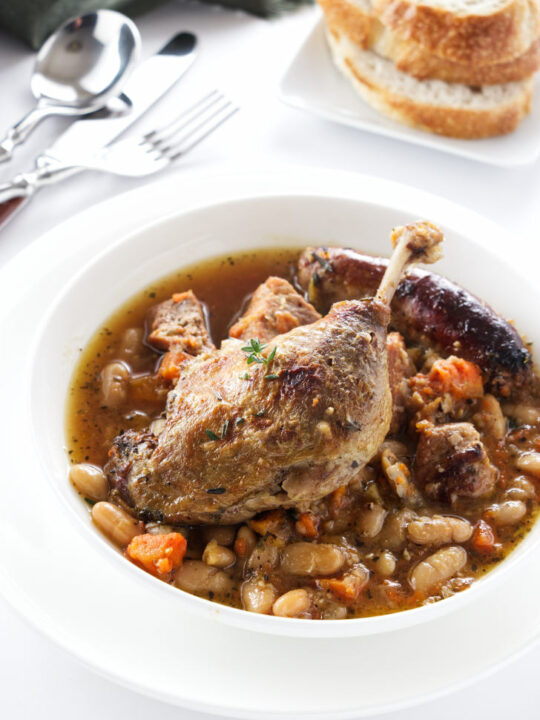 A serving of cassoulet topped with a duck leg