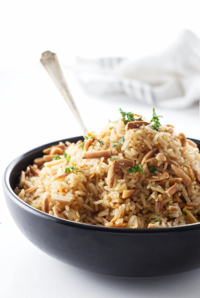 A bowl of rice pilaf with almonds.