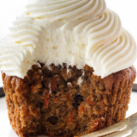A serving of carrot cake cup cake with cream cheese frosting