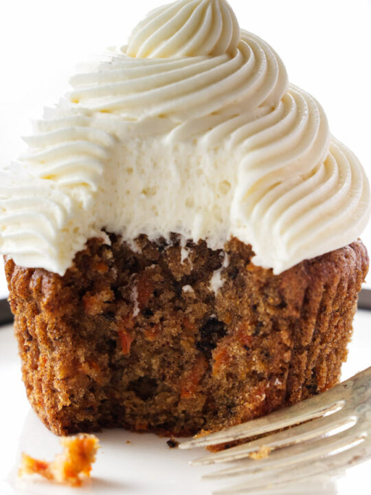 A serving of carrot cake cup cake with cream cheese frosting
