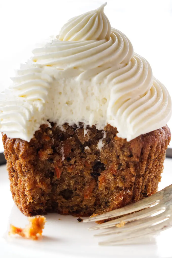 A serving of carrot cake cup cake with cream cheese frosting