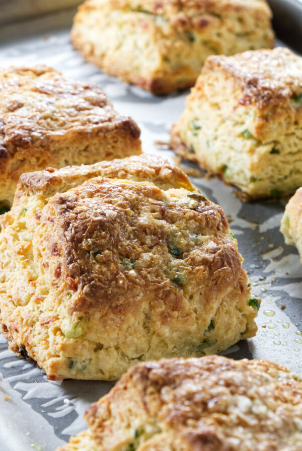 Freshly baked sour cream and onion biscuits on a baking sheet.