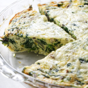 A pie dish with a crustless quiche.