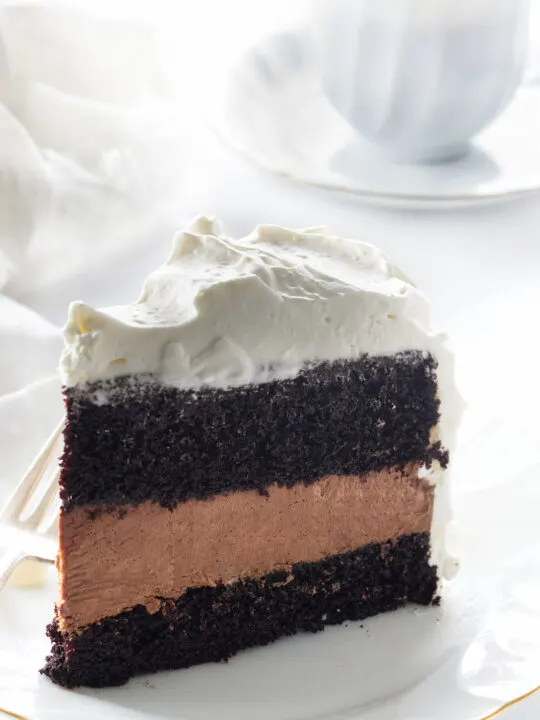 Chocolate cake layer, mousse layer, cake layer and a thick layer of whip cream