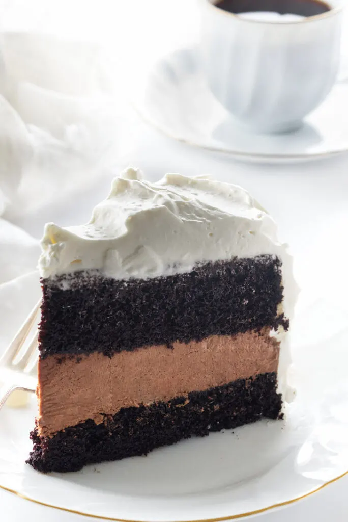 Chocolate cake layer, mousse layer, cake layer and a thick layer of whip cream