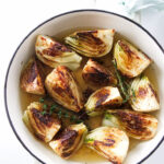 A skillet filled with wedges of fennel.